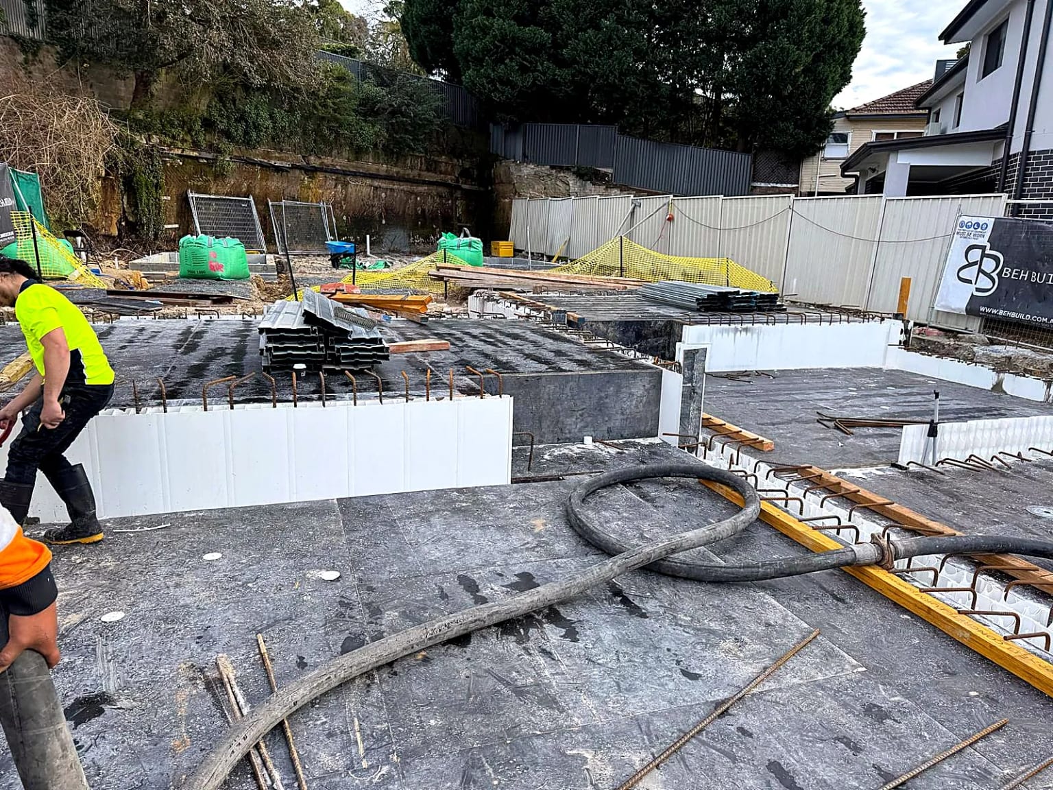 Concrete slabs, starter bars and materials arranged across the project site.