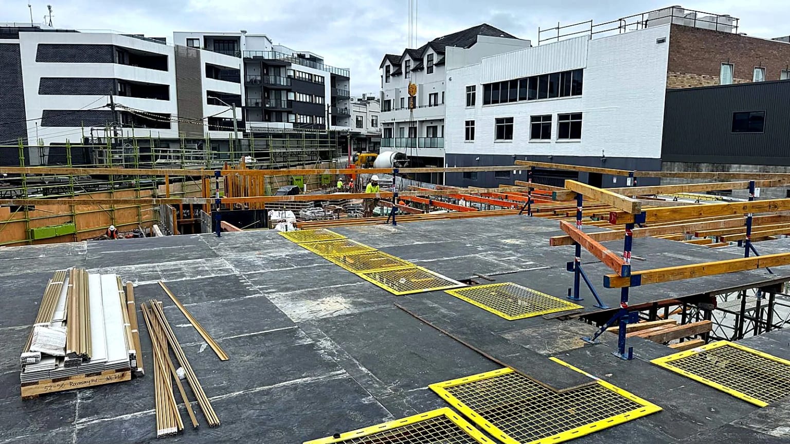 Formwork deck panels installed with yellow safety screens over openings.
