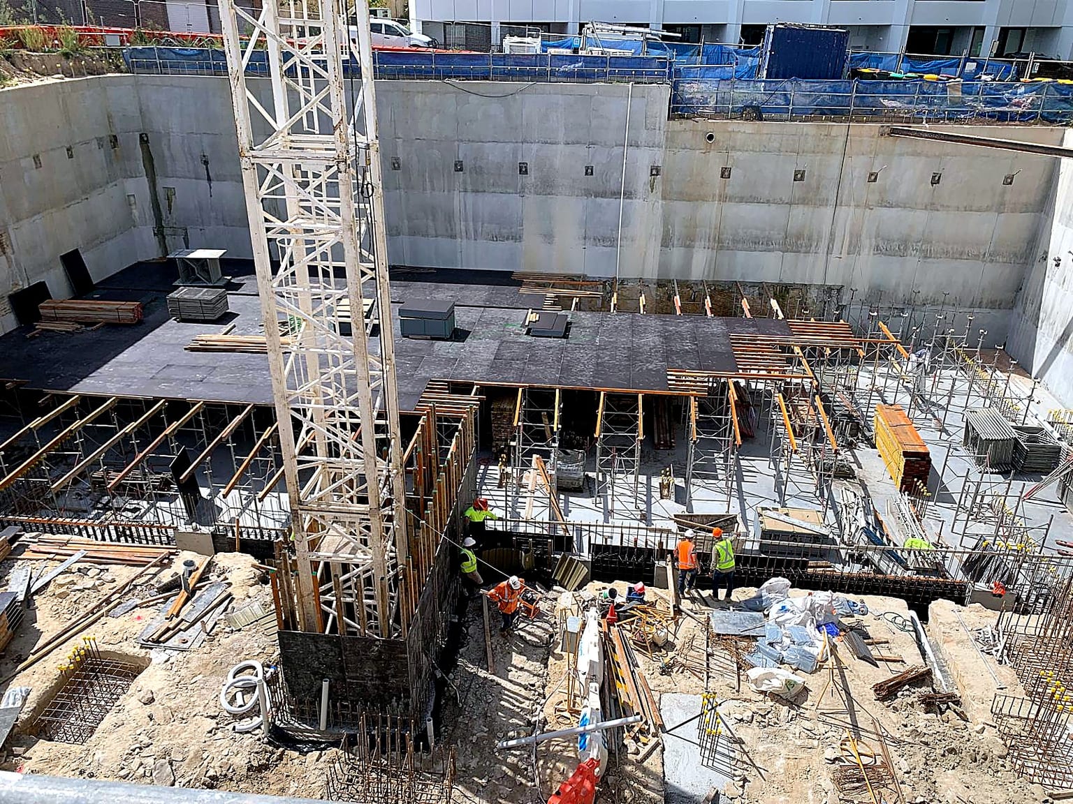 Aerial view of deck formwork and shoring arranged around the tower crane.