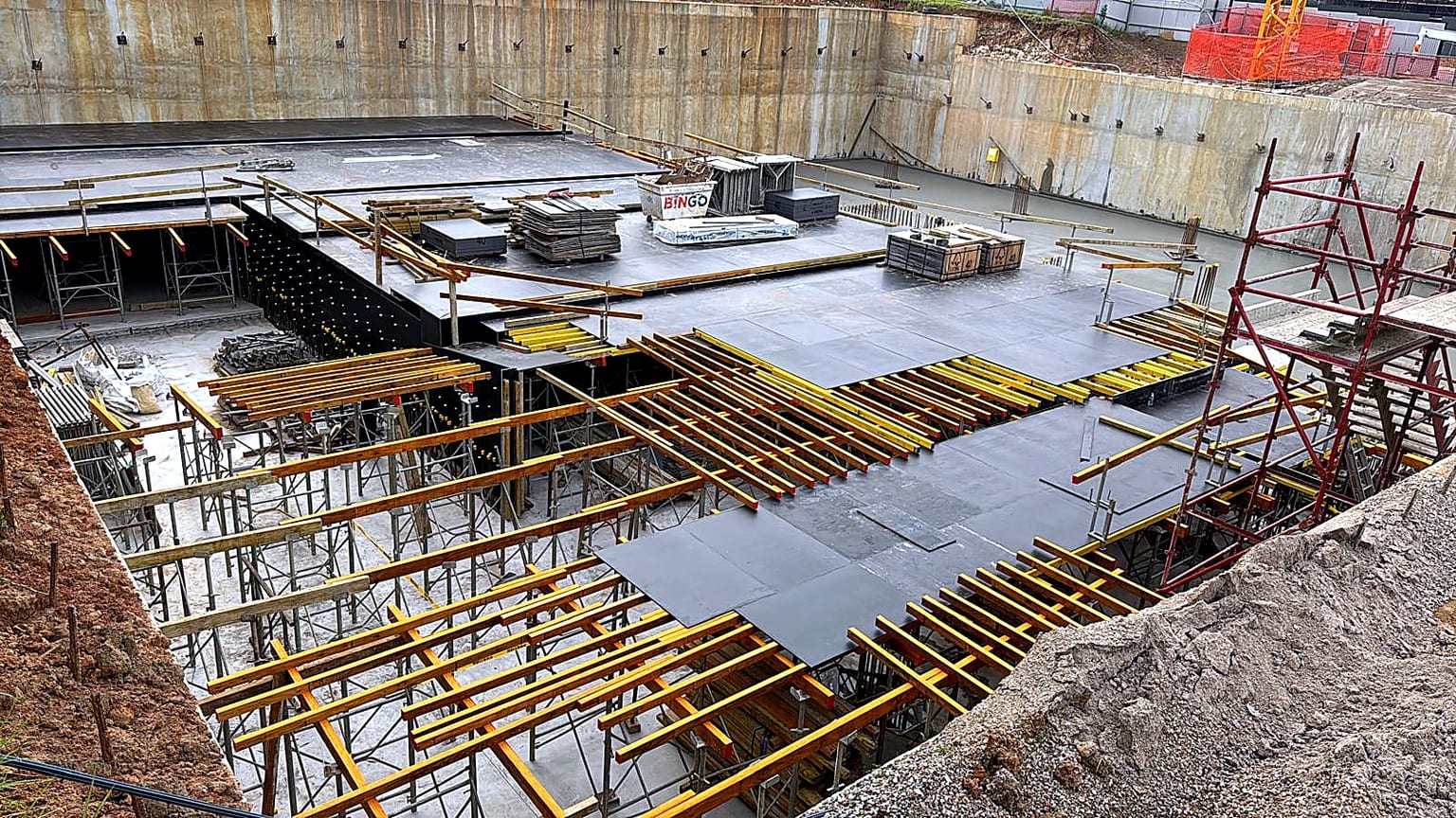 Suspended slab formwork with plywood panels, timber bearers and shoring inside an excavation.