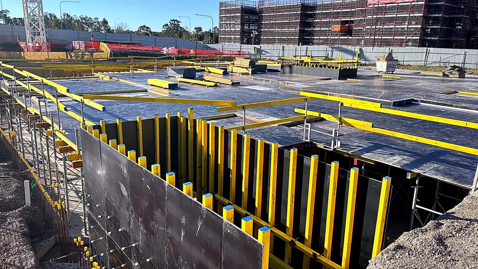 Yellow edge framing around installed black deck formwork.