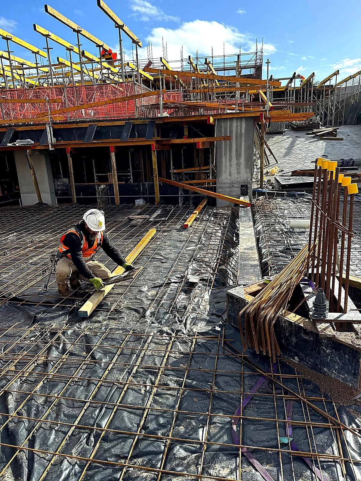 Worker setting timber above reinforcement and slab edge formwork.