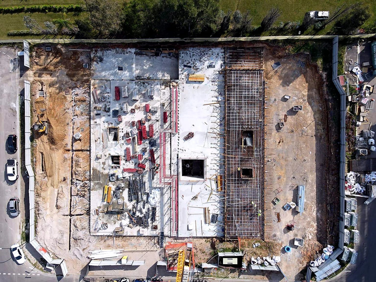 Vertical aerial view of concrete slabs and a reinforced strip under construction.