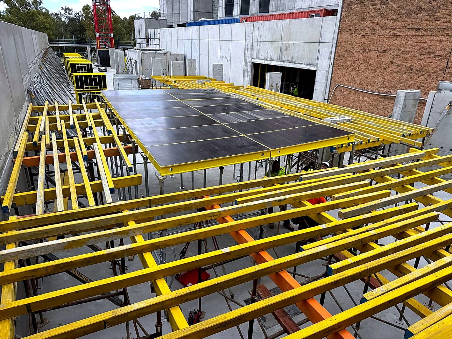 Yellow beams and table formwork supporting an elevated deck.