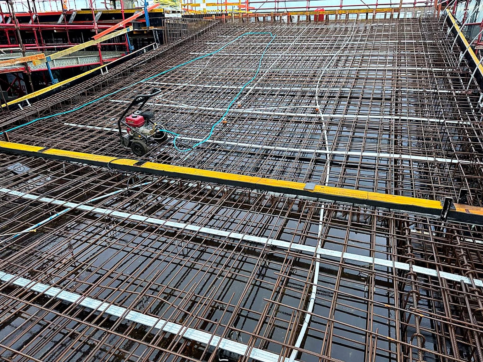 Dense reinforcement and service conduits prepared across a slab.