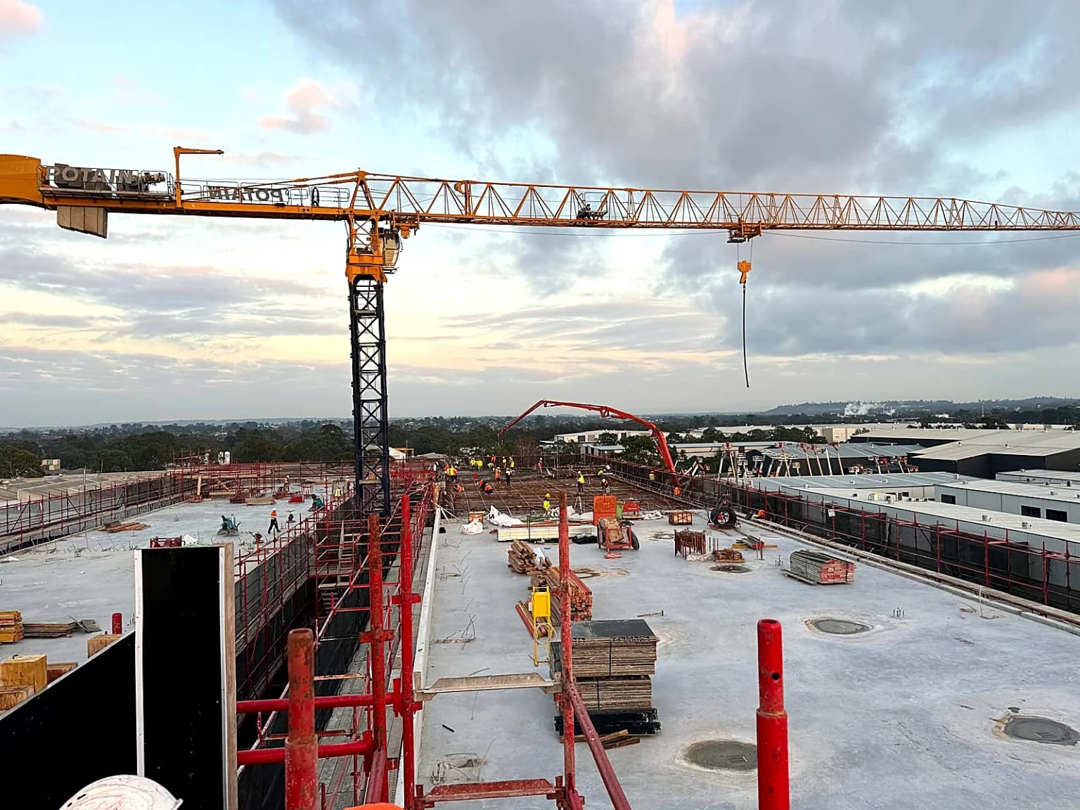 Tower cranes spanning a broad concrete deck during reinforcement work.