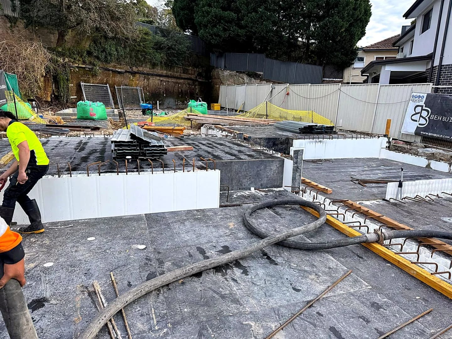 Concrete slabs, starter bars and materials arranged across the project site.