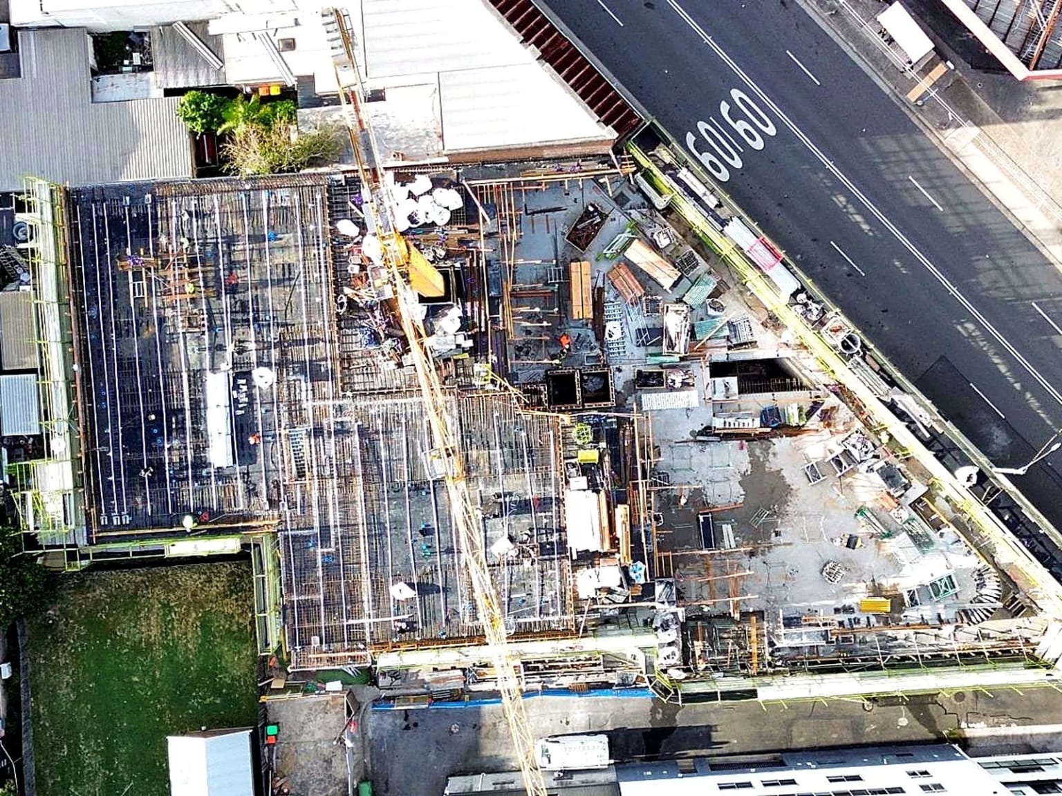 Aerial view of a tower crane spanning slab and formwork construction.
