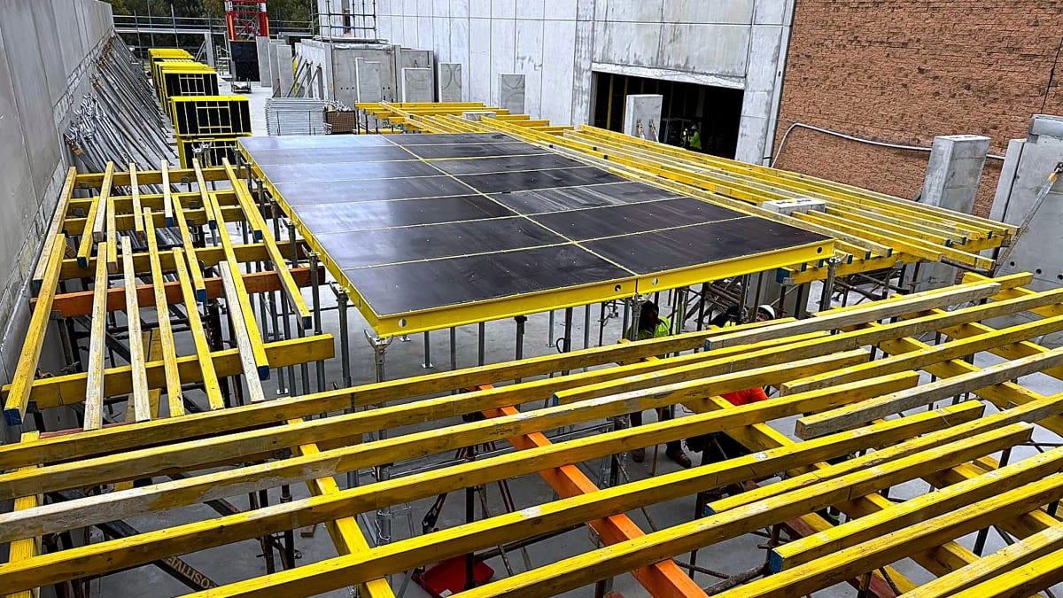 Yellow beams and modular formwork panels assembled for a suspended slab.